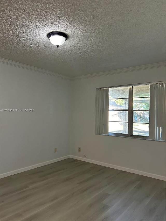 spare room featuring ornamental molding, hardwood / wood-style floors, and a textured ceiling