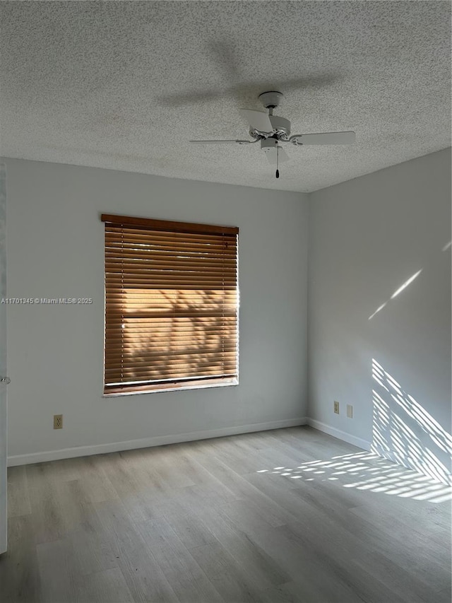 spare room featuring a textured ceiling, light hardwood / wood-style flooring, and ceiling fan