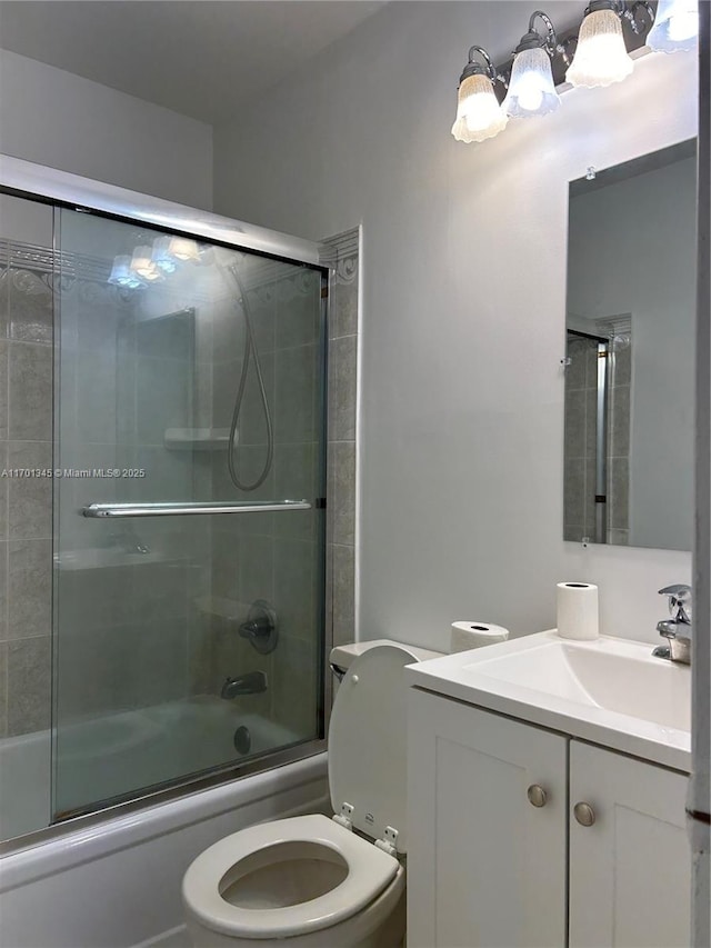 full bathroom with vanity, combined bath / shower with glass door, and toilet