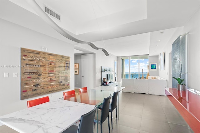 tiled dining room featuring floor to ceiling windows