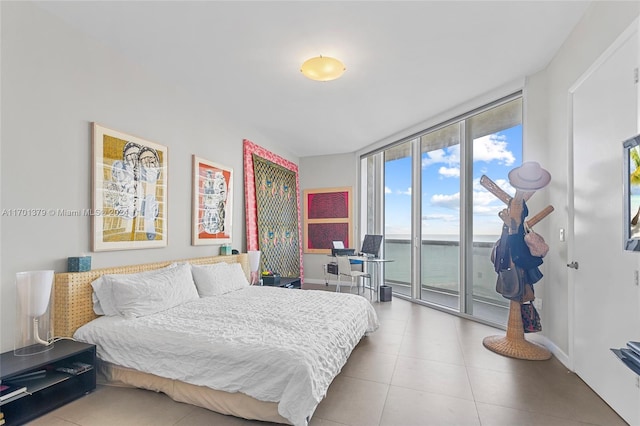 tiled bedroom with access to outside and a water view