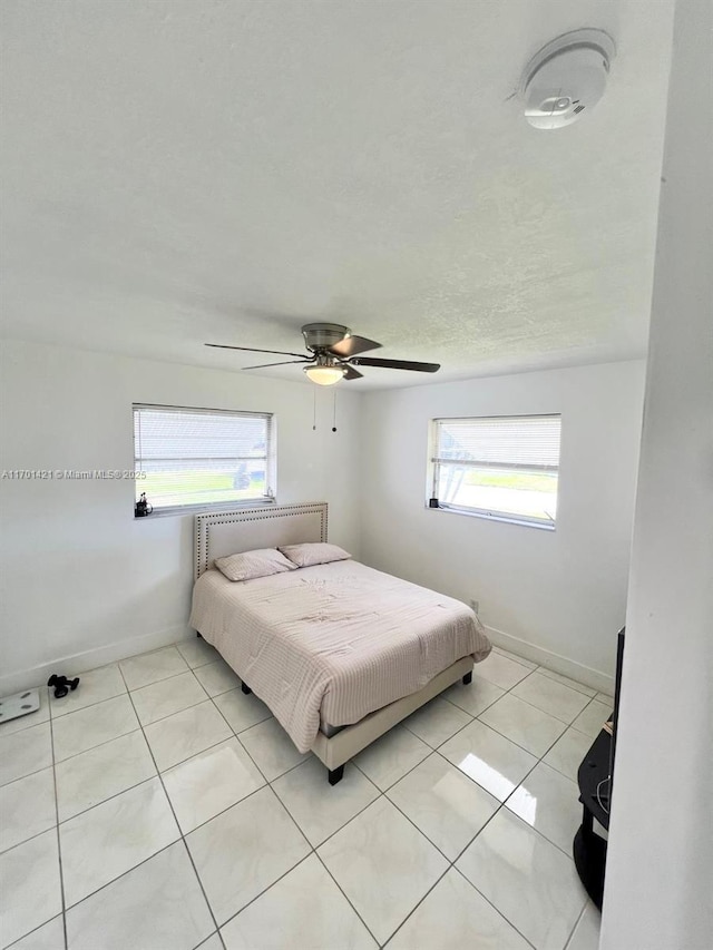 bedroom with light tile patterned floors and ceiling fan