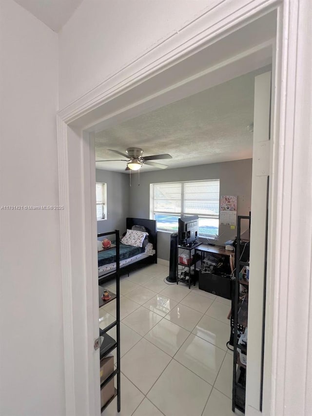 bedroom with ceiling fan and light tile patterned floors