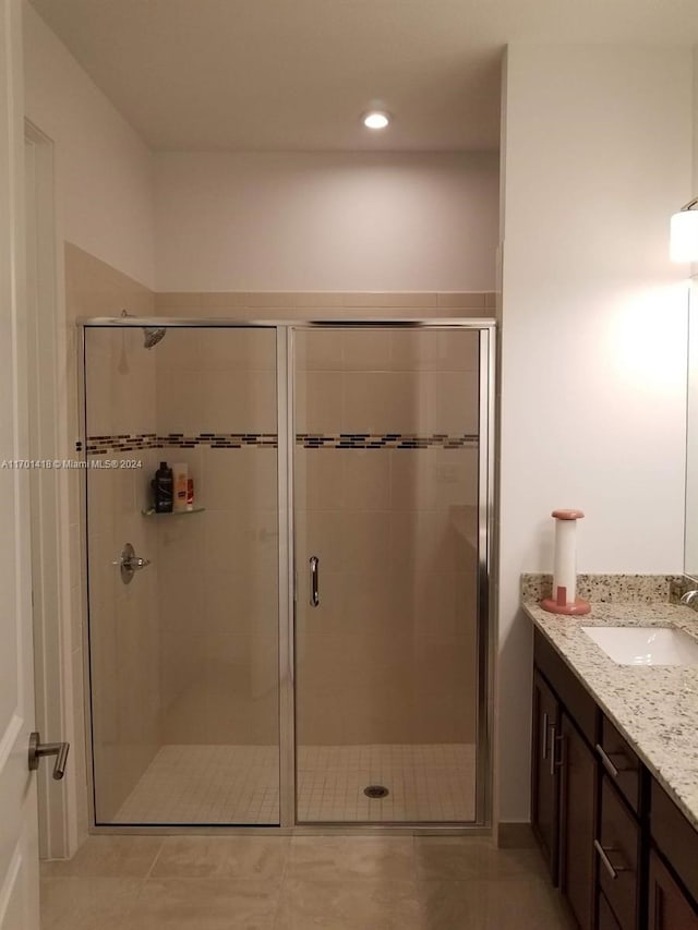 bathroom featuring tile patterned flooring, vanity, and an enclosed shower