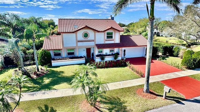 mediterranean / spanish home featuring a garage and a front yard