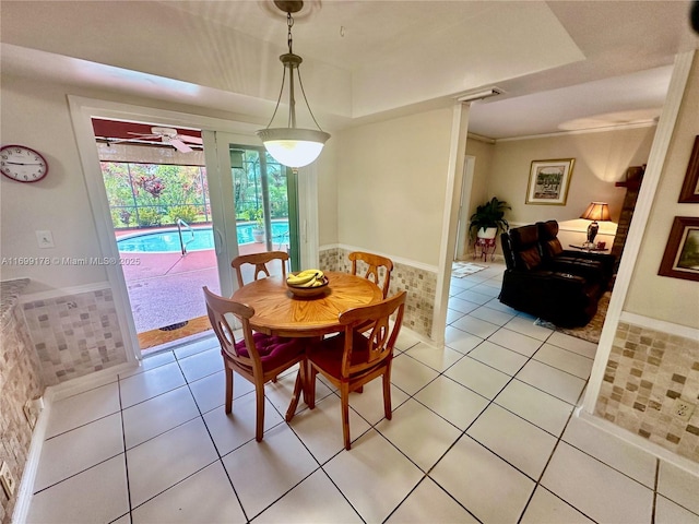 dining room featuring light tile patterned floors and a raised ceiling