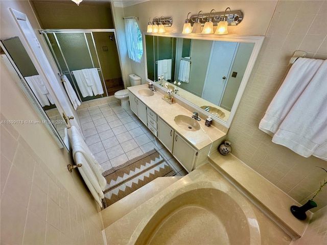 bathroom with tile patterned floors, vanity, toilet, and a shower with door