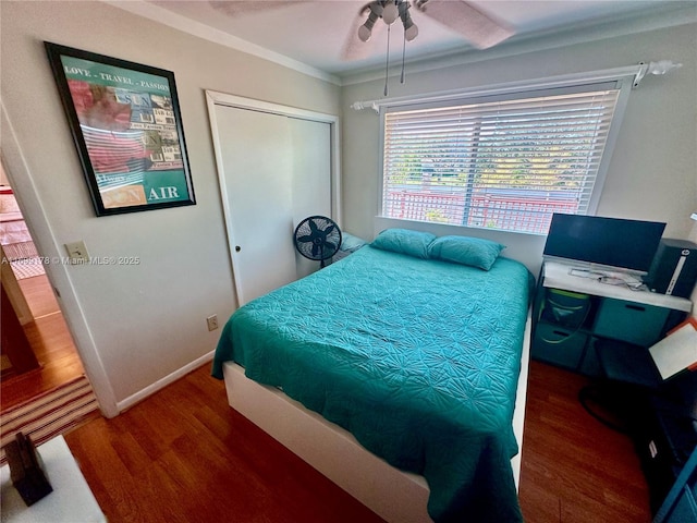 bedroom with dark hardwood / wood-style flooring, a closet, ceiling fan, and crown molding