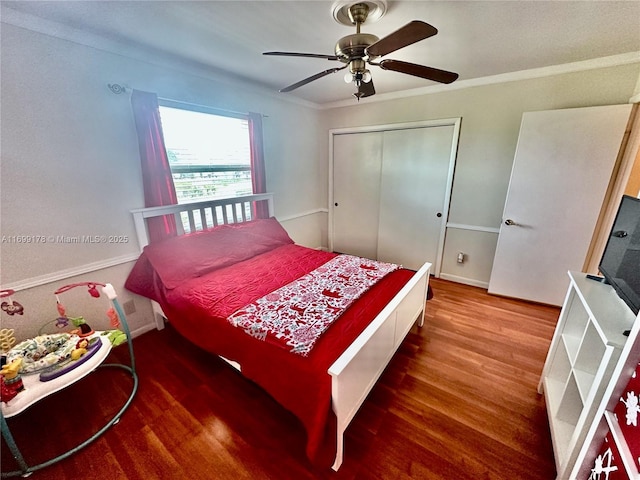 bedroom with ceiling fan, wood-type flooring, crown molding, and a closet