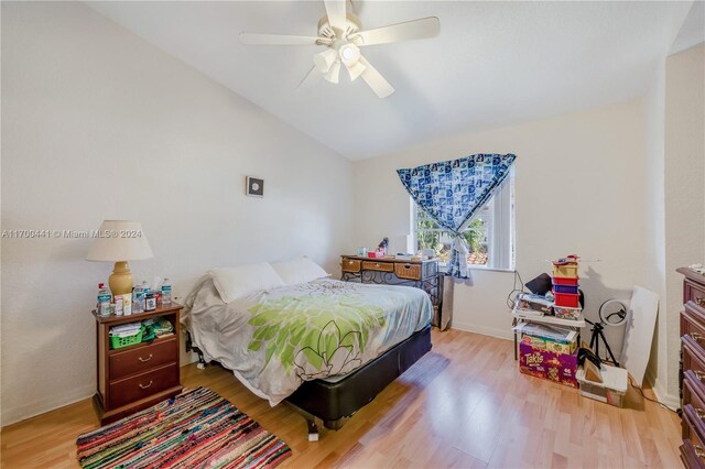 bedroom featuring ceiling fan, light wood-type flooring, and lofted ceiling