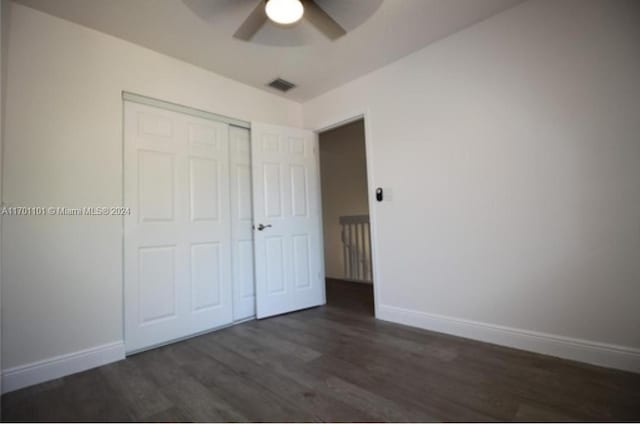 unfurnished bedroom with dark hardwood / wood-style floors, ceiling fan, and a closet