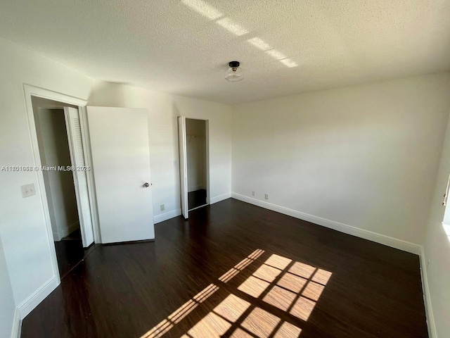 unfurnished bedroom featuring dark hardwood / wood-style flooring and a textured ceiling