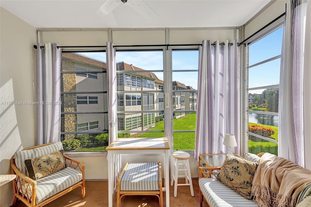 sunroom featuring a wealth of natural light, a water view, and ceiling fan