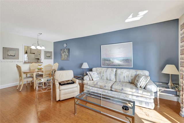 living room featuring hardwood / wood-style flooring, a textured ceiling, and a chandelier