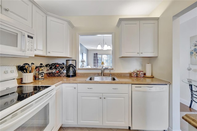 kitchen with white cabinetry, sink, a chandelier, and white appliances