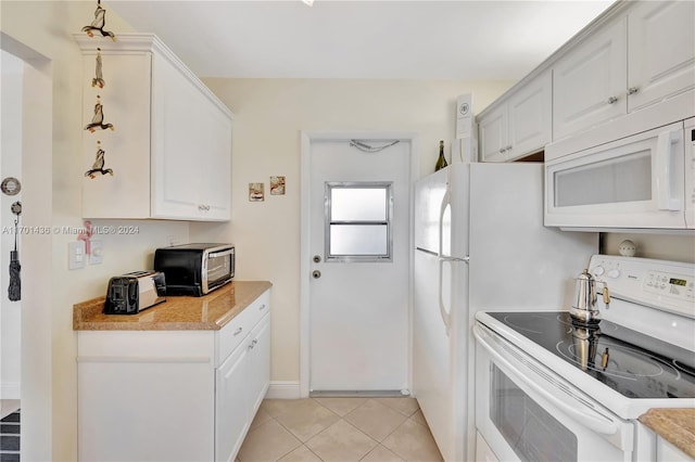 kitchen featuring white cabinetry, light tile patterned floors, and white appliances