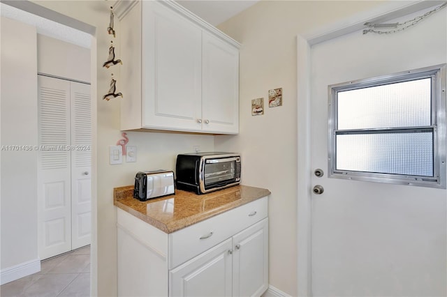 kitchen with white cabinets and light tile patterned floors