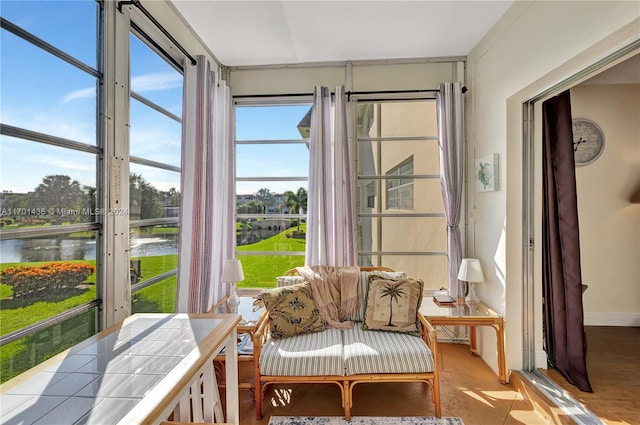 sunroom / solarium featuring a water view and a healthy amount of sunlight