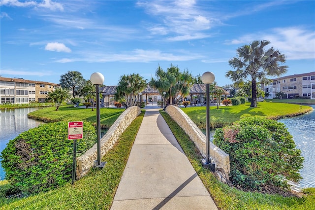 view of property's community featuring a lawn and a water view