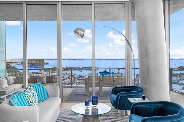 living room with floor to ceiling windows, a water view, and wood-type flooring