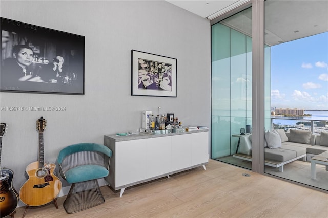 interior space featuring white cabinetry, light hardwood / wood-style flooring, and a wall of windows