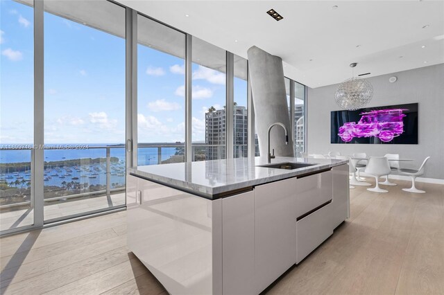 2675 S Bayshore Dr Unit 1602S, Miami, FL 33133 - kitchen with a sink, modern cabinets, white cabinets, floor to ceiling windows, and a kitchen island with sink