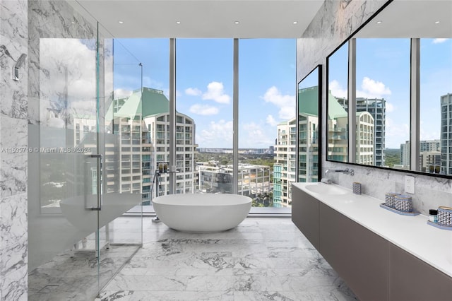 bathroom with a bathtub, a wall of windows, and vanity