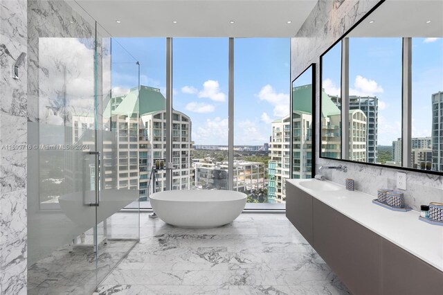 2675 S Bayshore Dr Unit 1602S, Miami, FL 33133 - full bathroom featuring a wall of windows, marble tiled floors, a city view, a freestanding bath, and vanity