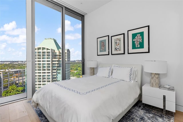 bedroom with hardwood / wood-style flooring and floor to ceiling windows