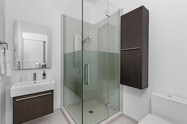 bathroom with tile patterned flooring, vanity, an enclosed shower, and toilet