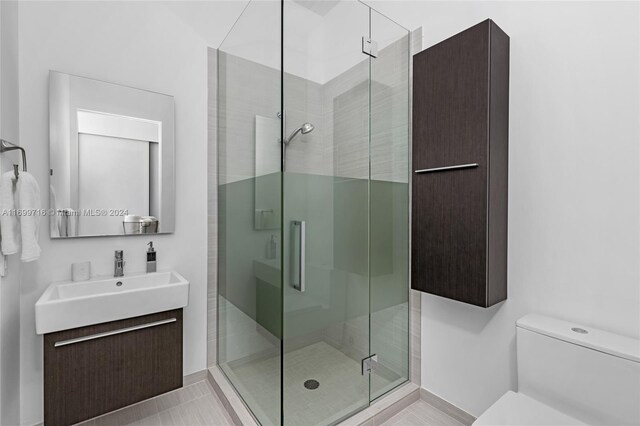 2675 S Bayshore Dr Unit 1602S, Miami, FL 33133 - bathroom featuring a shower stall, vanity, toilet, and baseboards