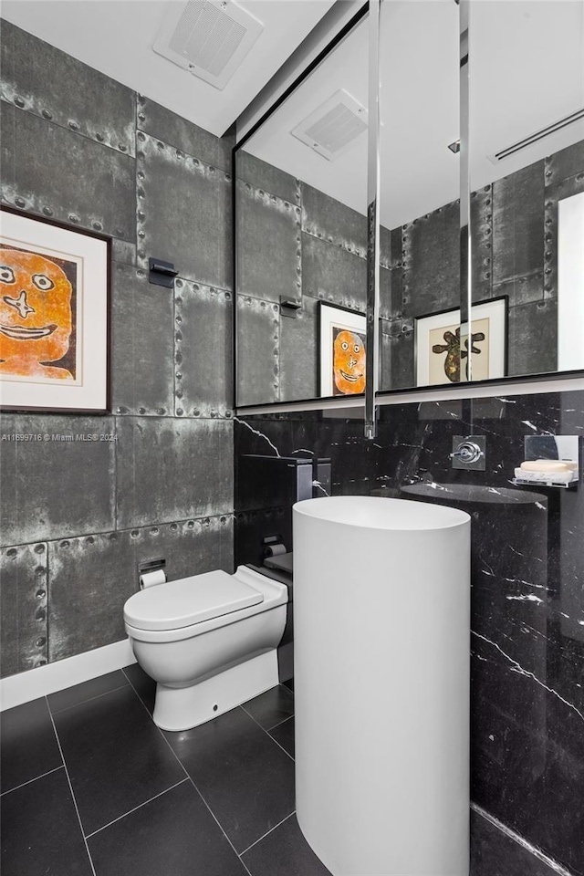 bathroom featuring tile patterned floors, vanity, toilet, and tile walls