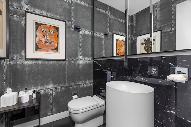 bathroom featuring tile patterned floors, toilet, and tile walls