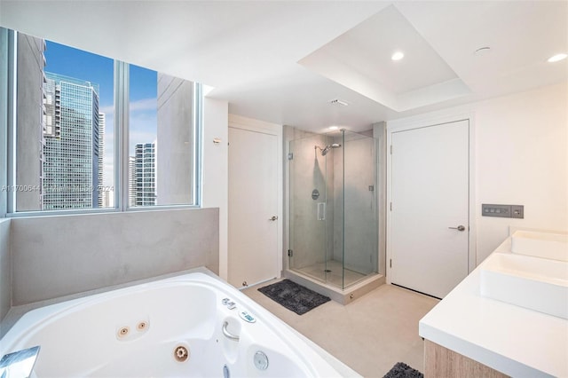 bathroom featuring vanity, plus walk in shower, and a tray ceiling