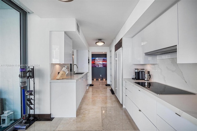 kitchen featuring tasteful backsplash, white cabinetry, black electric stovetop, and extractor fan