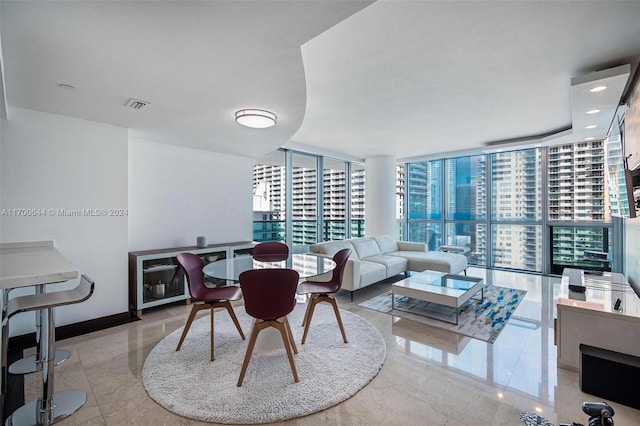 dining space with light tile patterned floors and a wall of windows