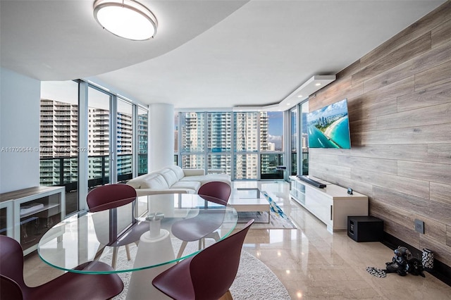 dining space with wood walls and expansive windows