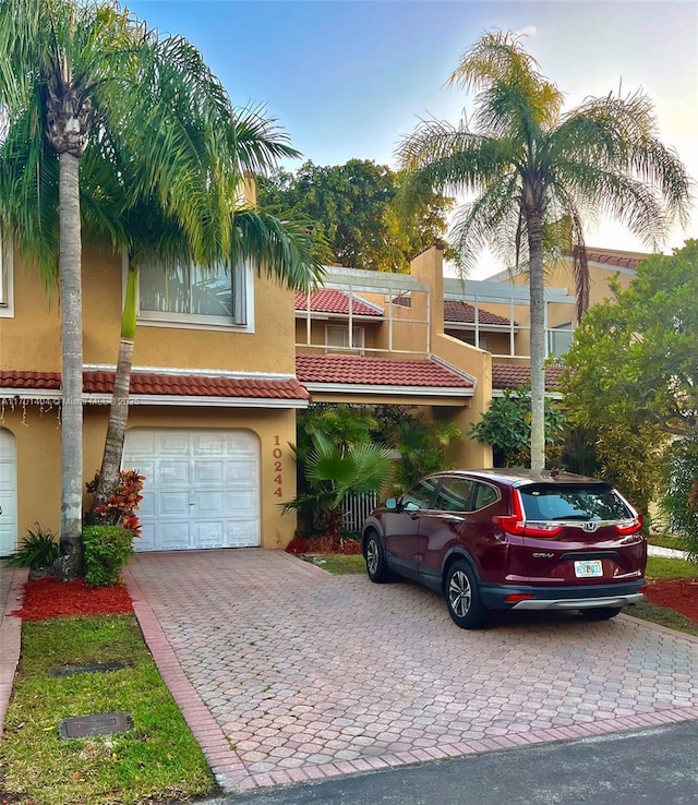 10244 NW 51st Ter, Doral, FL 33178 - view of front facade with stucco siding, an attached garage, and decorative driveway