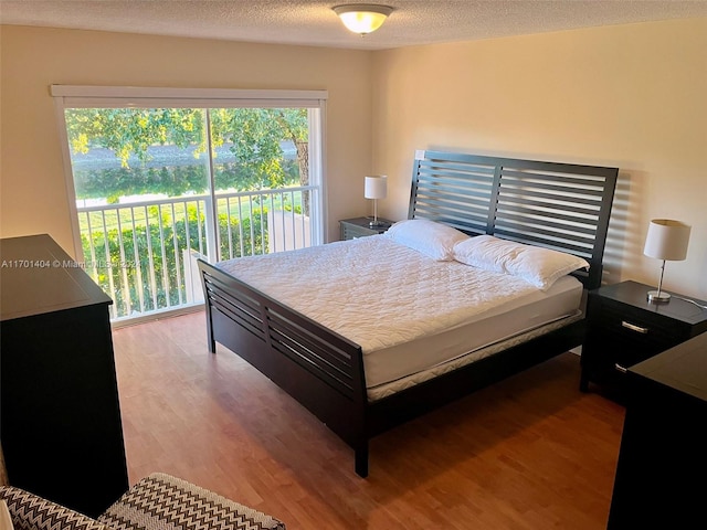 bedroom with hardwood / wood-style floors and a textured ceiling