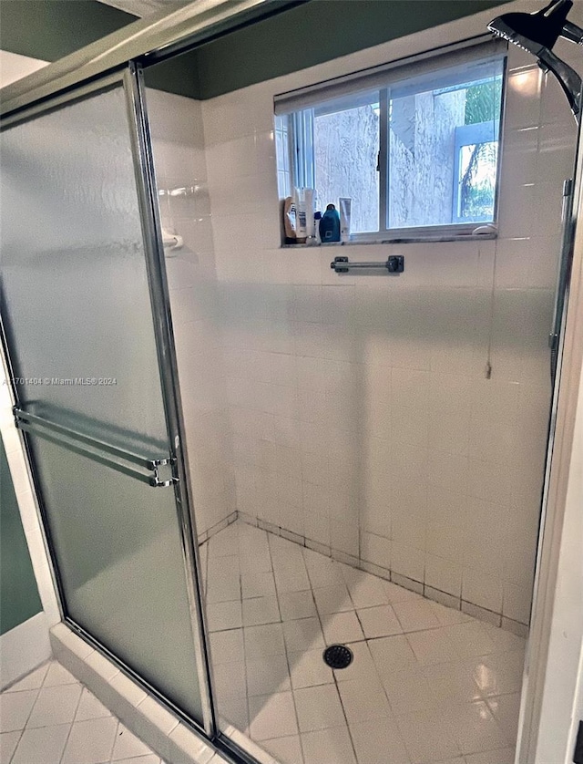 bathroom featuring tile patterned floors and a shower with shower door