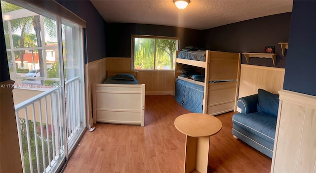 bedroom with multiple windows, light hardwood / wood-style flooring, and a textured ceiling