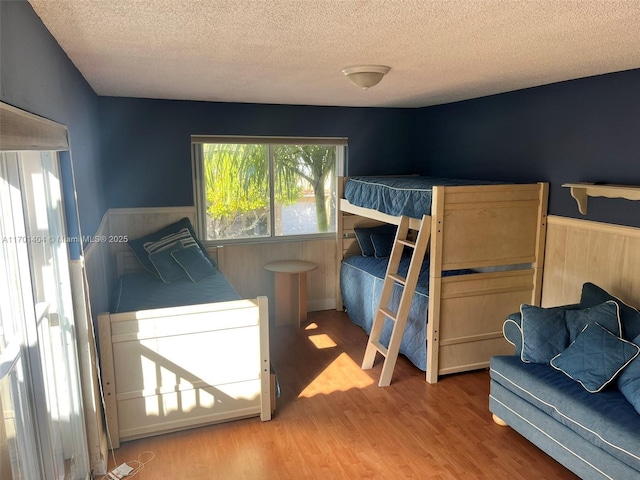 10244 NW 51st Ter, Doral, FL 33178 - bedroom featuring a wainscoted wall, a textured ceiling, and wood finished floors