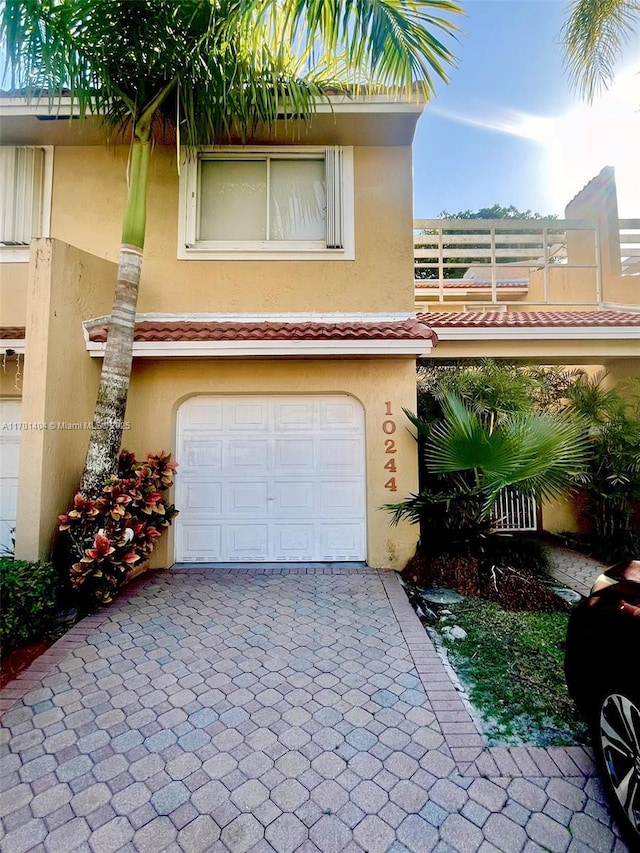 10244 NW 51st Ter, Doral, FL 33178 - view of front of house featuring a tiled roof, stucco siding, decorative driveway, and a garage