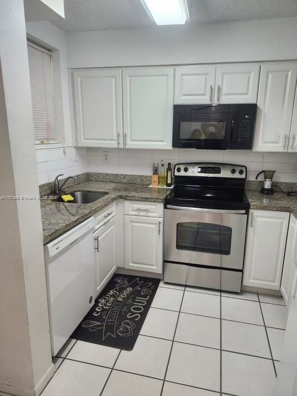 kitchen featuring backsplash, stainless steel range with electric cooktop, white dishwasher, white cabinets, and sink