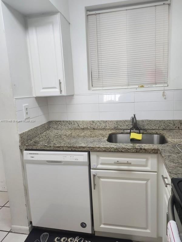 kitchen with white dishwasher, sink, stainless steel range, tasteful backsplash, and white cabinetry