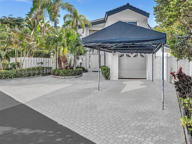 view of parking with a garage and fence