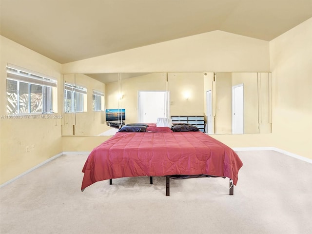 carpeted bedroom with vaulted ceiling and baseboards