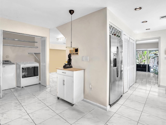 kitchen with white cabinets, stainless steel fridge with ice dispenser, marble finish floor, washer and dryer, and recessed lighting