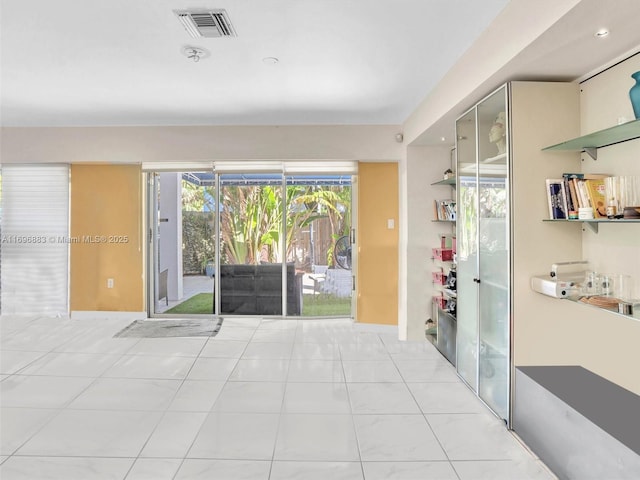 unfurnished room with light tile patterned floors and visible vents