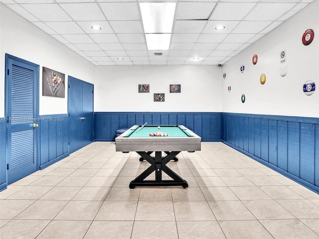 game room featuring a paneled ceiling, a wainscoted wall, visible vents, and light tile patterned floors